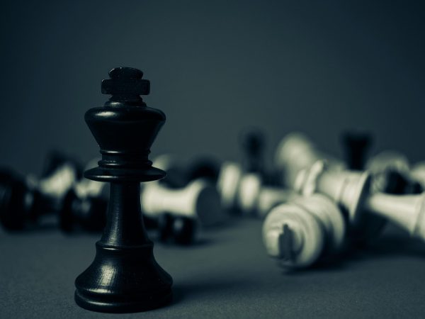 游戏盒子我的游戏库界面，显示已收藏、最近游玩与下载进度条，桌面暖光照在手机屏幕上